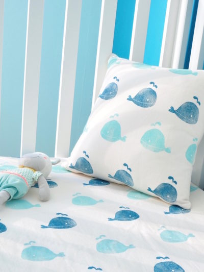 Chambre enfant sur-mesure écologique. Coussin et drap housse assortis petites baleines imprimé à la main sur du coton biologique par Inkree