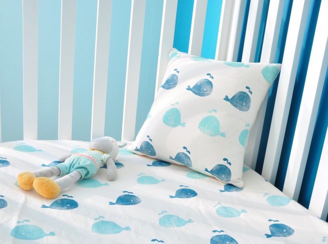 Chambre enfant sur-mesure écologique. Coussin et drap housse assortis petites baleines imprimé à la main sur du coton biologique par Inkree